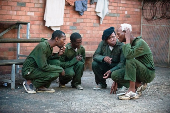 Pictured in the prison courtyard China Boy (Presley Chweneyagae) and Buttons (Warren Masemola) decide on Magadien's (Mothusi Magano) fate.